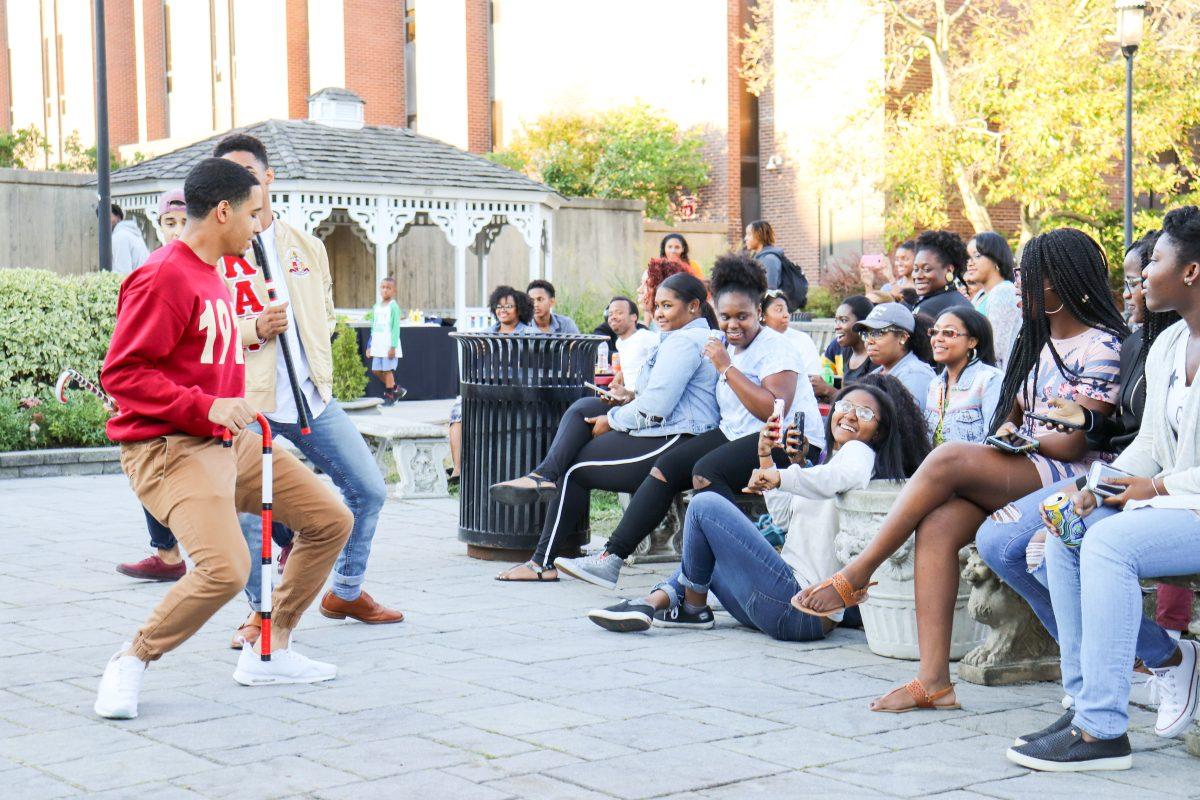 Members of Kappa Alpha Psi perform a stomp routine as students watch in excitement (Photo by Charley Rekstis 20).