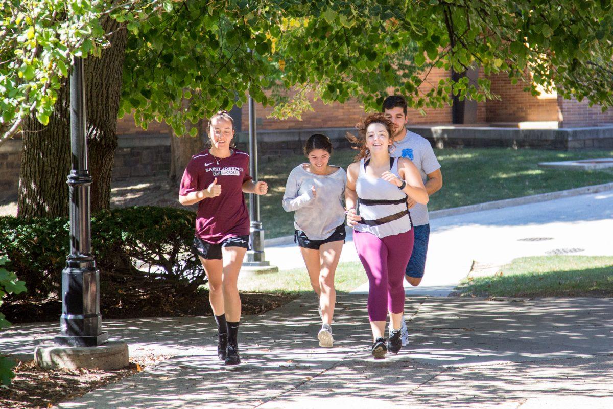 Rebecca Lane 19, Daniella Capone 18, Carlena Griesemer 19 and Josh Luciano 19 go for a run during class as part of Thomas Coynes Running to Write course (Photo by Luke Malanga 20). 