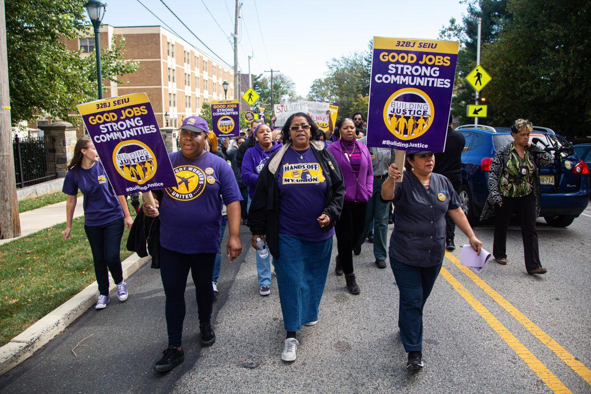 Rose Weldon (middle), a member of the St. Joes cleaning staff, leads the march to the corner of Cardinal Ave and City Ave. PHOTO: LUKE MALANGA 20