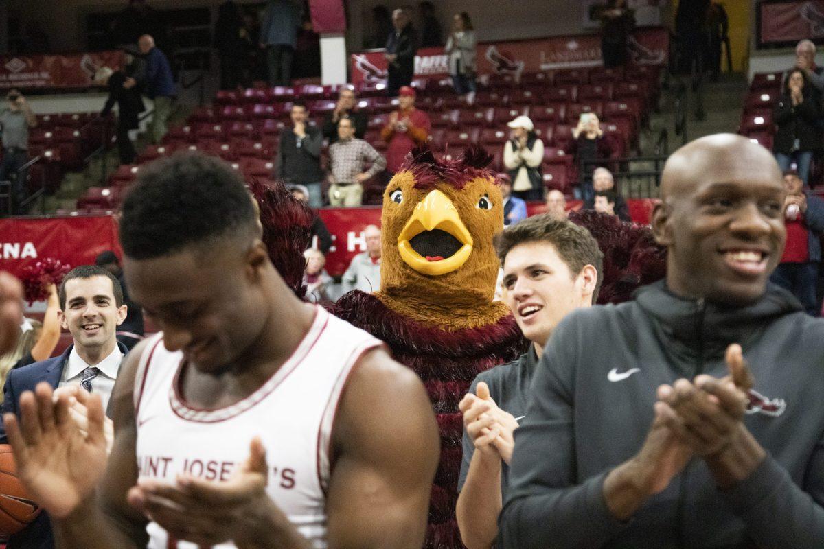 The Hawk stands among members of the St. Joe’s men’s basketball team after a win over Bradley University.
PHOTO: MITCHELL SHIELDS ’22/THE HAWK