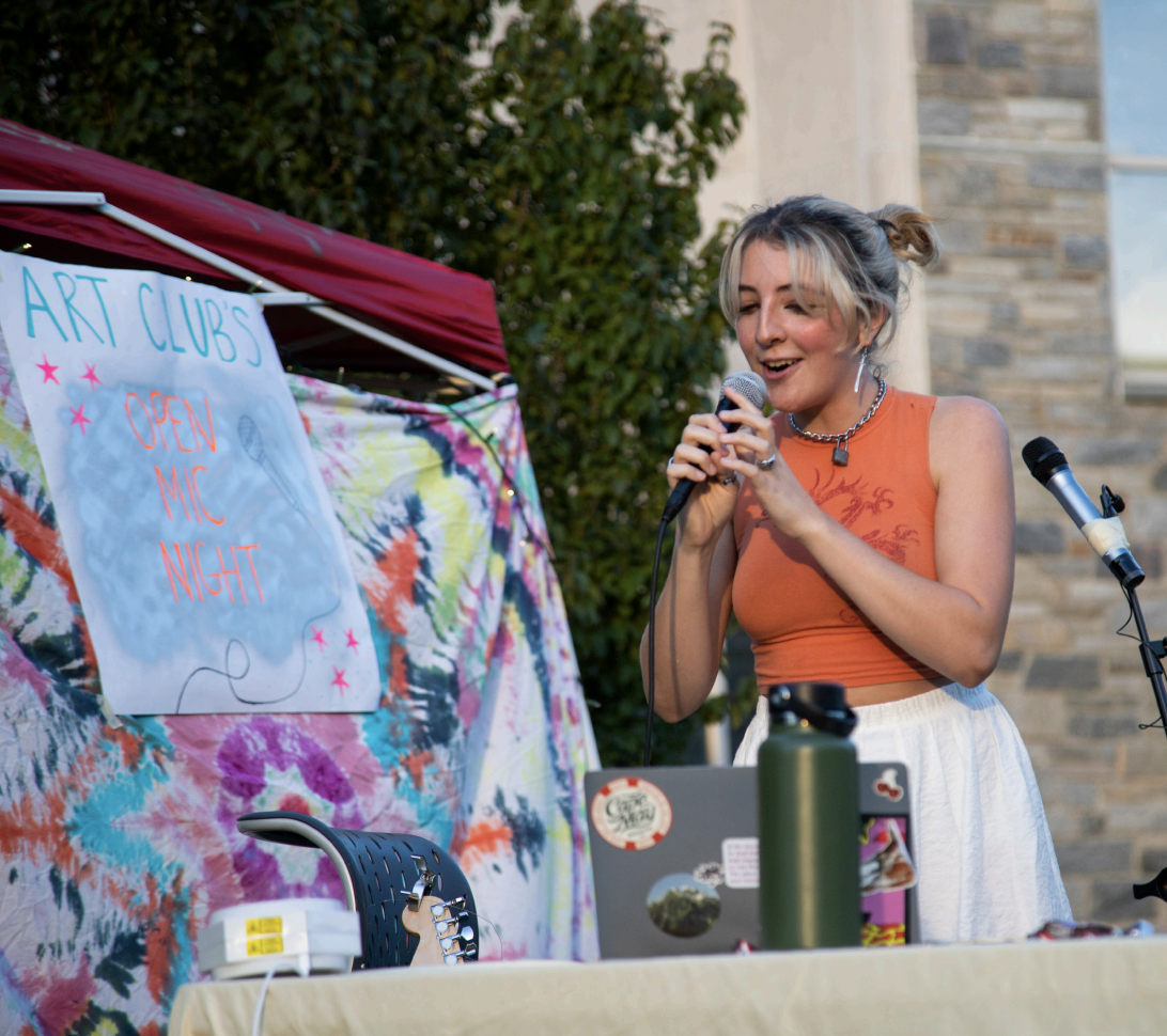Jayne Baran ’22 performs at the art club’s Open Mic Night on Sept. 20. Before the pandemic, the event would typically be held inside. But due to COVID-19 protocols, it
was held on Villiger Lawn with an audience of about 20 students. PHOTO: KELLY SHANNON ’24/THE HAWK