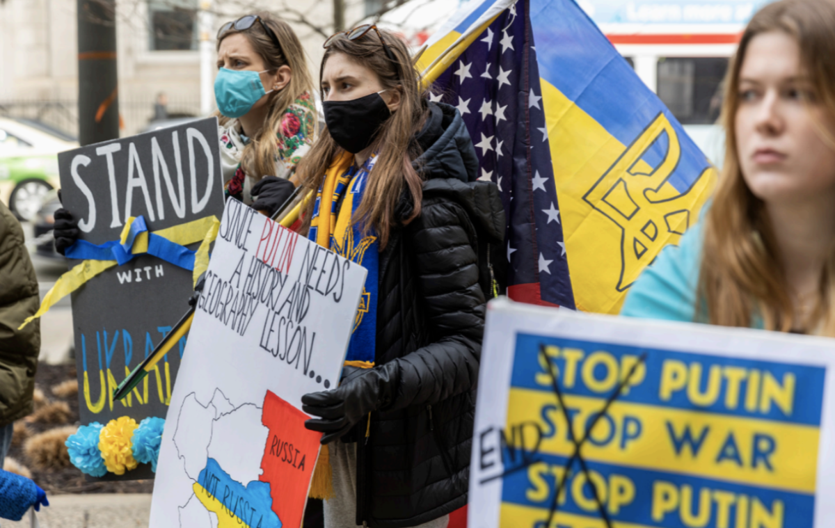 Natalie Yaworsky Lamley (left) and her cousin Daria Heletkanycz (center) show their support for Ukraine at a Feb. 25 rally at City Hall. Both of their parents are from Ukraine. PHOTOS: MITCHELL SHIELDS 22/THE HAWK
