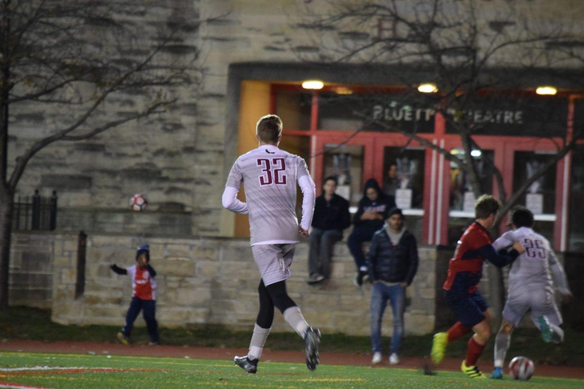 Sophomore+Kyle+Lochbihler+follows+the+action+as+senior+Eric+Jordan+fights+off+a+Duquesne+defender+%28Photo+by+Christy+Selagy%2C+M.A.%2C+17%29.
