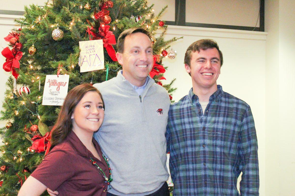 Left to right: Lauren Preski '20 Mark Reed, Ed. D., and Mark Bernstiel '20 take a picture with the tree from the 2016 tree lighting (Photo courtesy of SJU Student Senate).