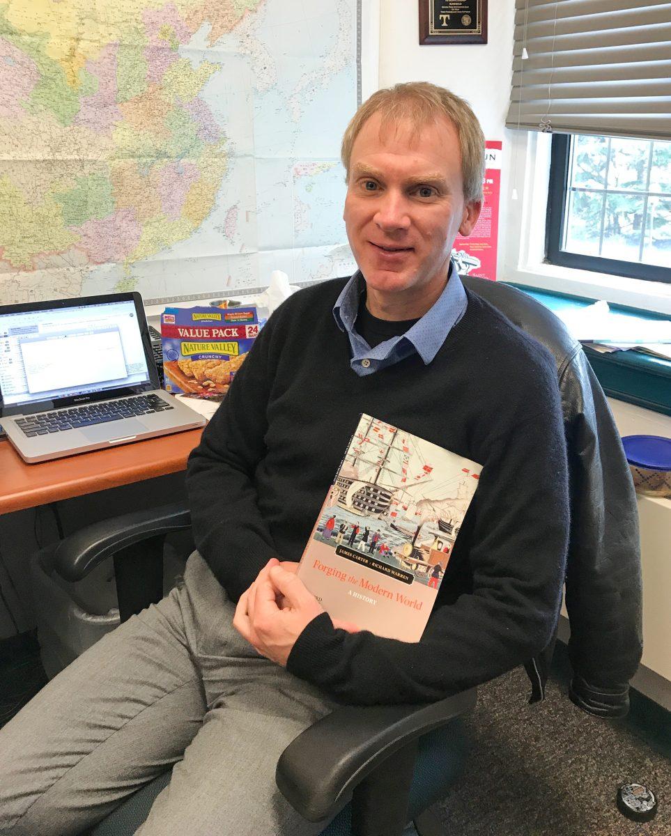 James Carter, Ph.D., with his textbook Forging the Modern World (Photo by Erin Duffy 20). 