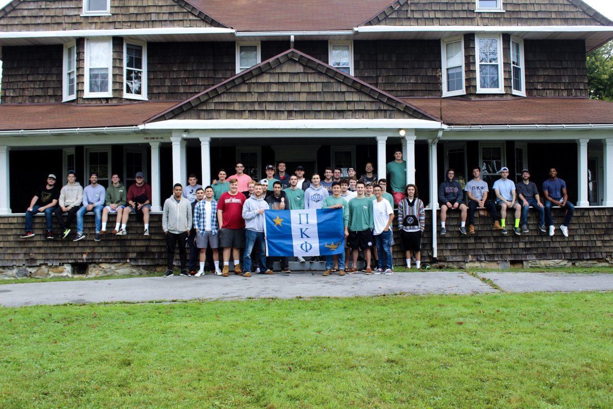 Pi+Kappa+Phi+brothers+pose+with+their+fraternity+flag+while+on+retreat+%28Photos+courtesy+of+James+Arcenas+%E2%80%9920%29.