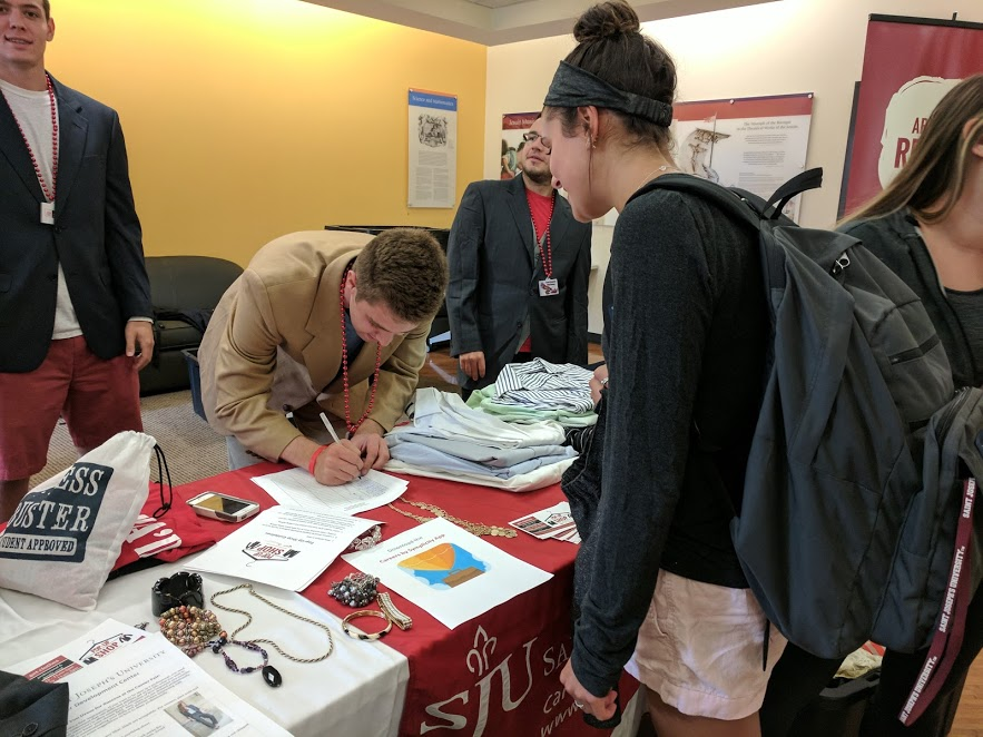 Students at a table at the pop-up shop with their chosen professional attire (Photo courtesy of Angela Yu ’18).