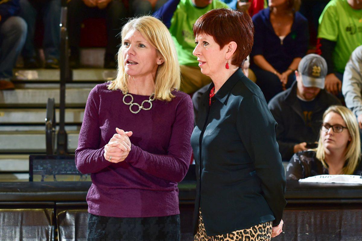 St. Joes womens basketball head coach Cindy Griffin (left) next to Notre Dame womens basketball head coach Muffet McGraw when the Hawks hosted the Irish in 2015 (Photo by Sideline Photos LLC).