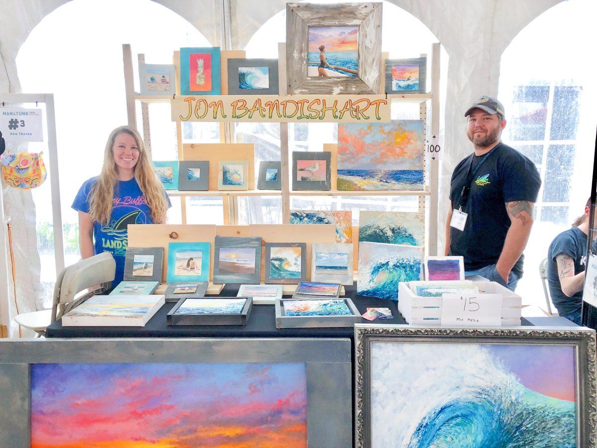 Jon Bandish alongside his girlfriend Avery Day with his original artwork in the emerging artists tent (Photo by Becky Barus 19).