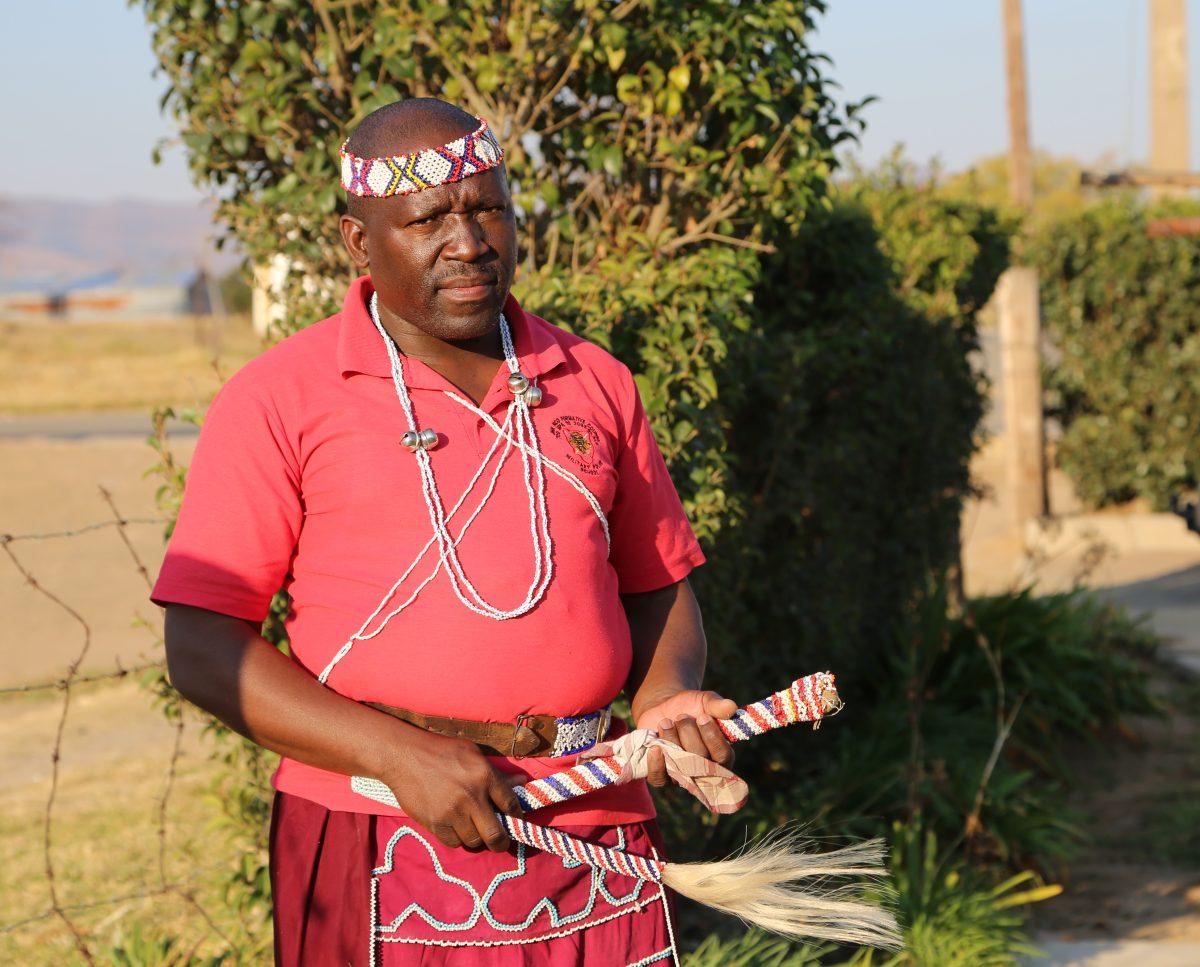 Jacob Mallane, outside his home in Mautse, was called to be a sangoma or spiritual healer when he was a young child. He now serves the people in his community as a sangoma, police officer and volunteer. Photo by Ibrahim Ridley 18