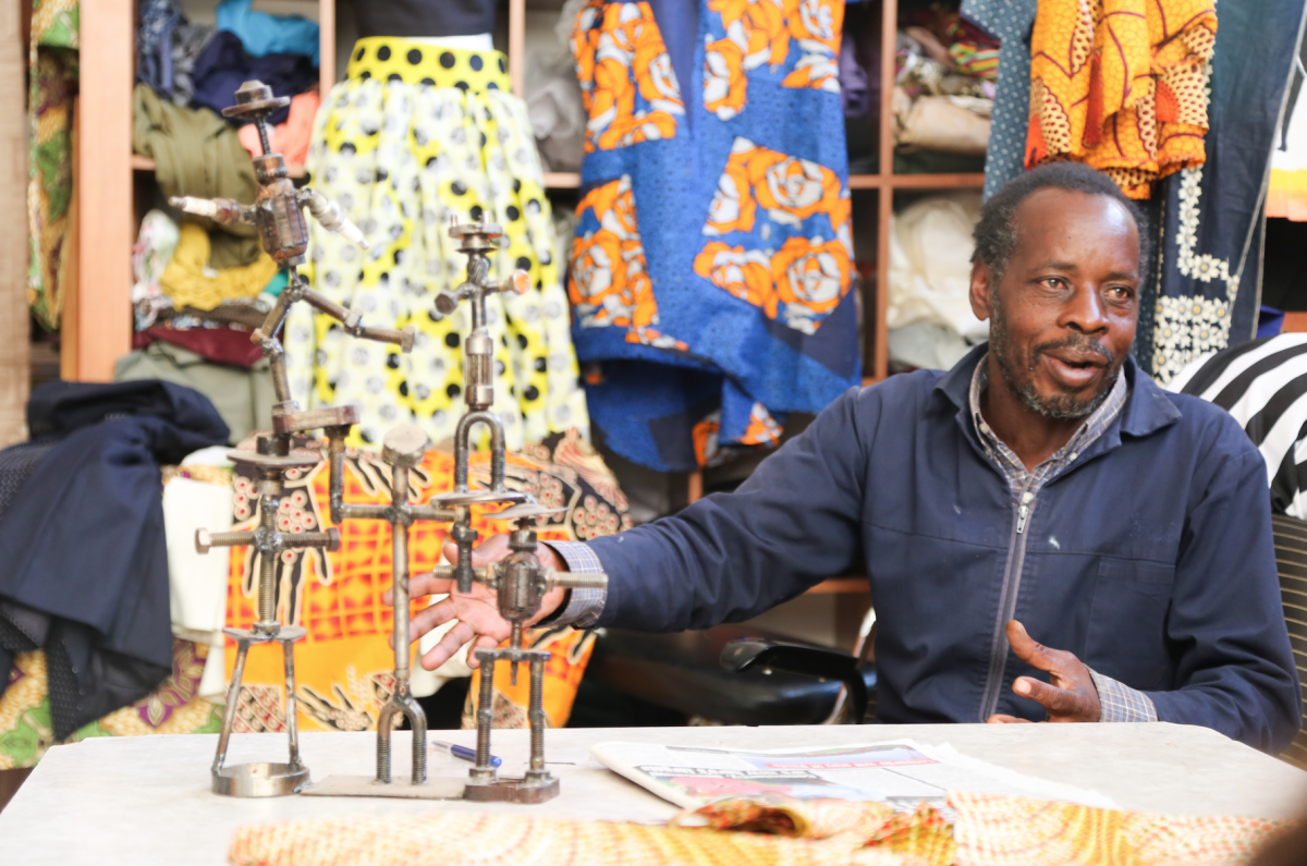 Givemore Tembo in his small studio showing a sculpture he made from scrap metal (Photo by Alim Young 19).
