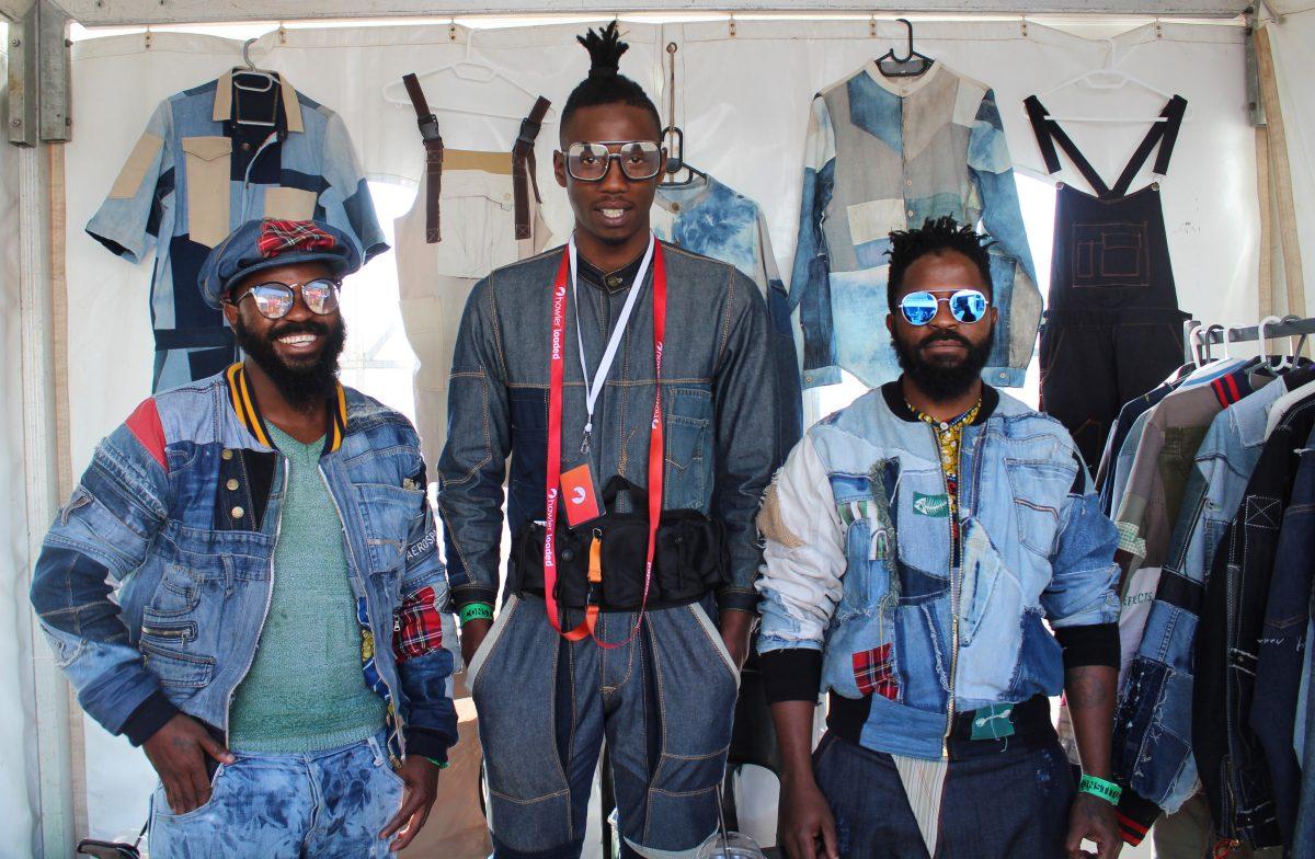 Designer Bandile Langa (left), stylist Luthando Tshabalala (center) and designer Andile Langa (right) stand inside their upcycled denim clothing company stand at the Basha Uhuru Freedom Festival. Their clothing brand, Lime EFFects, was coined by twin brothers Andile and Brandile Langa while in high school. Photo by Erin Breen 19.