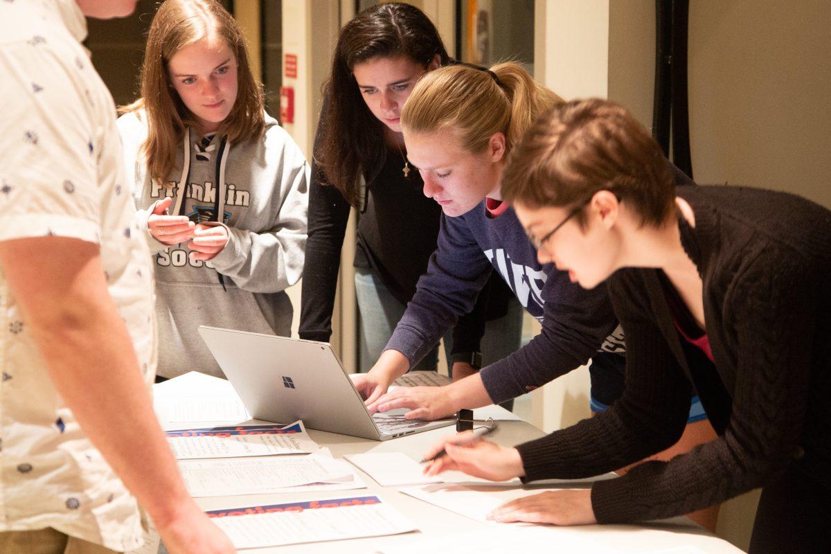 Sellars (far right) and Katy Green ’21 (second to right), help students register to vote (Photo by Luke Malanga ’20).