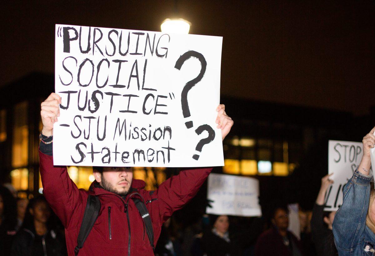 A student holds a sign at the silent protest on Dec. 3. PHOTO: LUKE MALANGA '20/THE HAWK