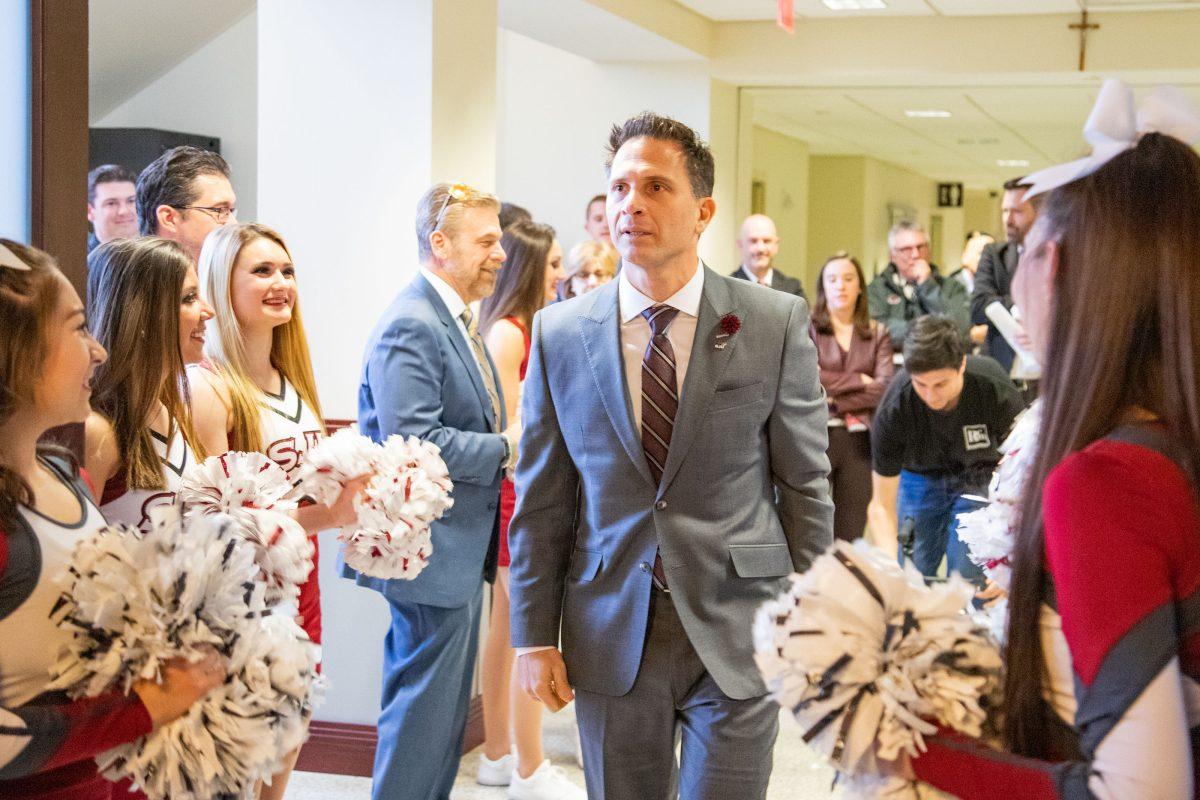 Billy Lange, newly appointed mens basketball head coach, walks into the Hall of Fame Room in Michael J. Hagan ’85 Arena. PHOTO: MITCHELL SHIELDS 22/THE HAWK