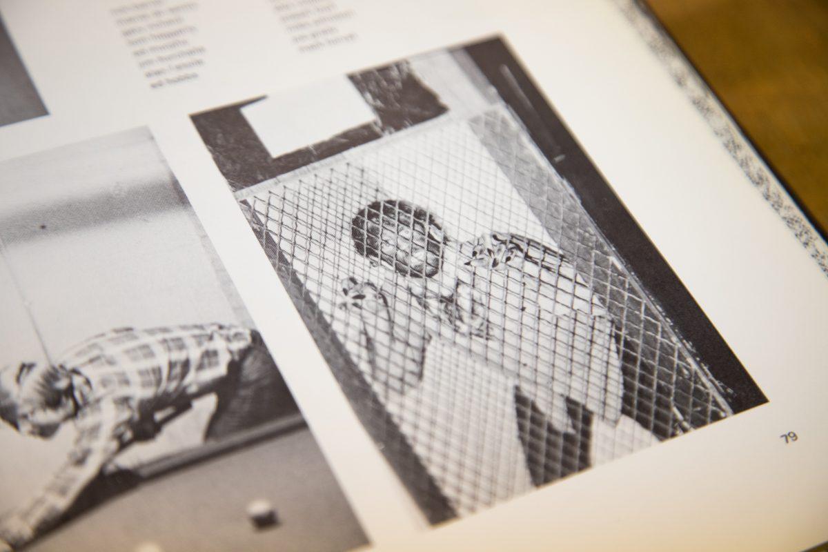 A white student in blackface poses behind a fence on page 79 of “The Greatonian” 1979 yearbook in the SJU Archives and Special Collections. PHOTO : MITCHELL SHIELDS ’22/THE HAWK