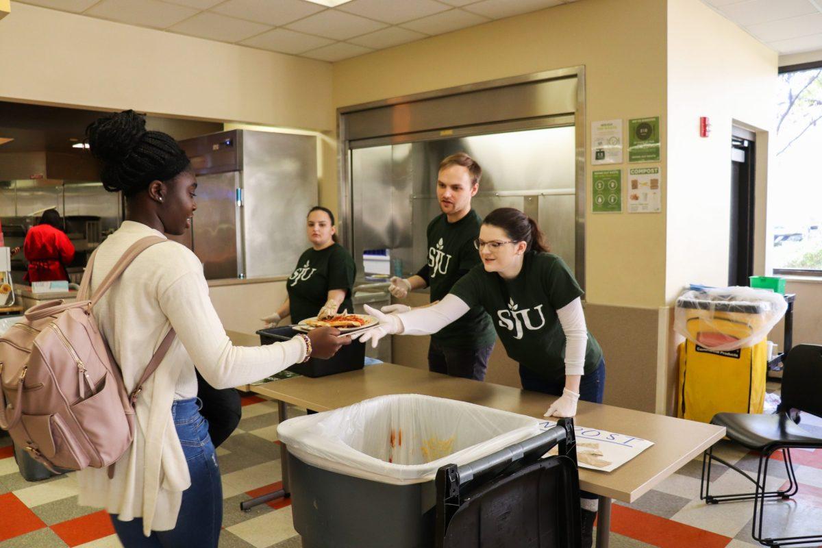 Deirde Taft-Lockard ’20 (right), co-president of SJU Green Fund, helps students dispose of leftover food and plastic packets in respective garbage bins before sending plates, utensils and cups to the dish pit during the “Weight of the Waste” event in Campion Dining Hall on Nov. 21. PHOTOS: Jackie Collins 21