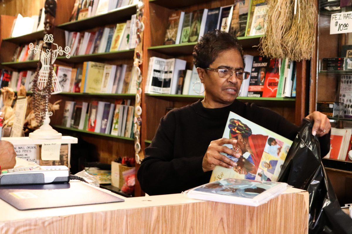 Yvonne Blake, the current owner of Hakim’s Bookstore, sits behind the counter of the shop while addressing a customer. PHOTOS: ALEX HARGRAVE ’20/THE HAWK