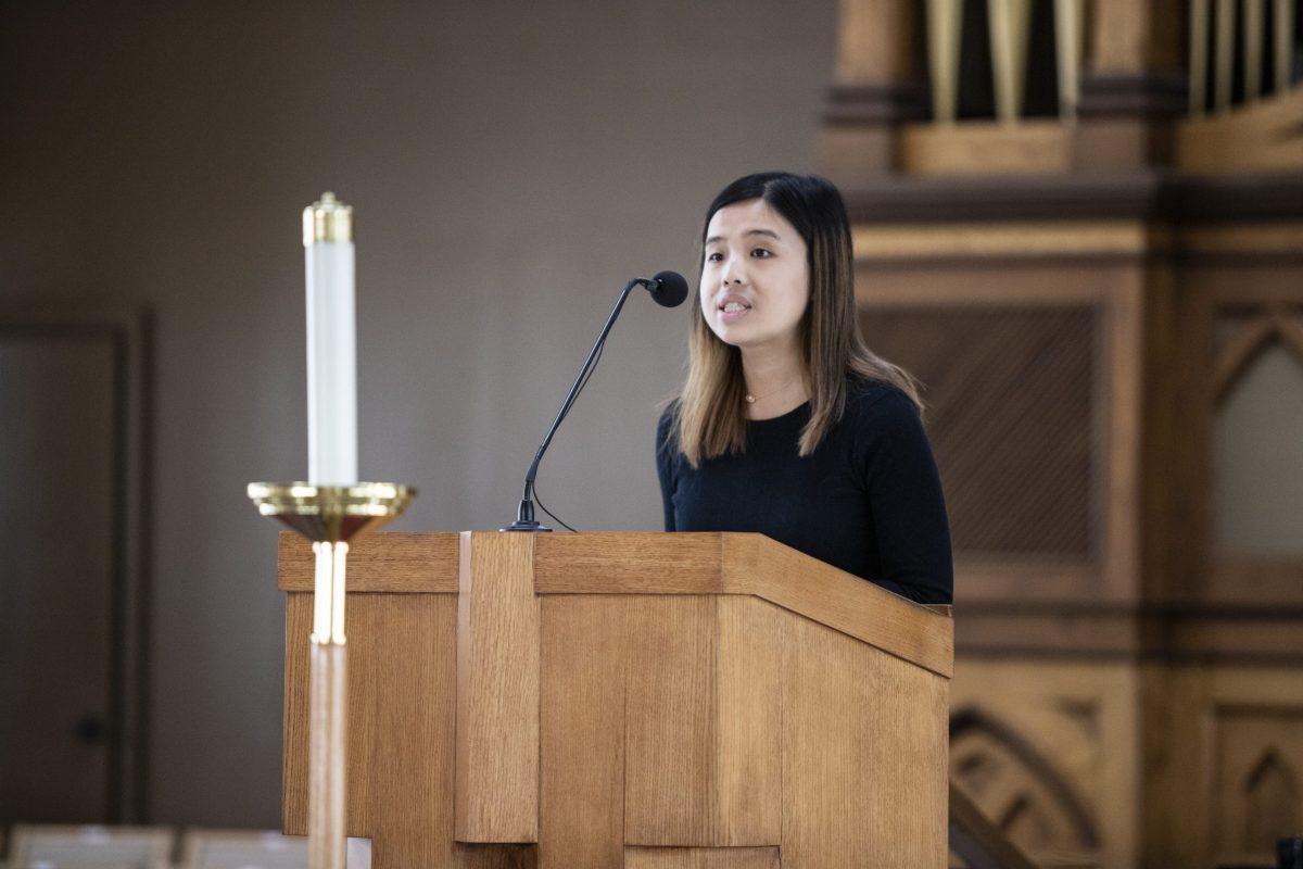 Joey Lam ’21 reads from a passage detailing the Buddhist faith. PHOTO: MITCHELL SHIELDS ’22/THE HAWK