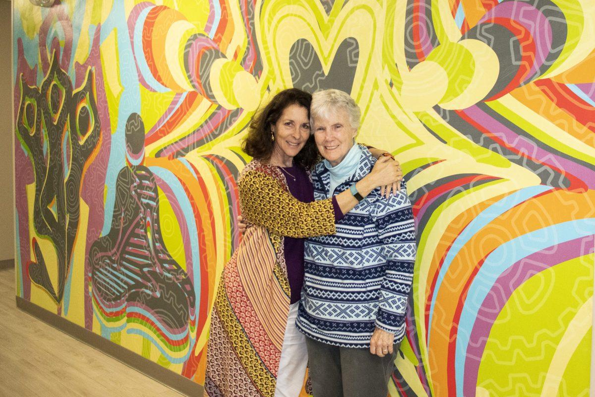 Sarina DiBianca (left) and Sister Bernadette Kinniry (right) pose for a photo in front a mural at the center.PHOTO: RYAN MULLIGAN ’21/THE HAWK