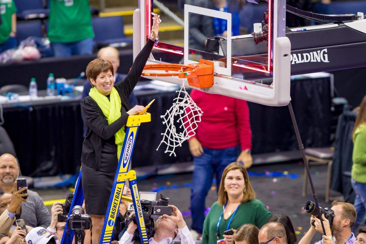 April 1, 2018; Head Womens Basketball Coach Muffet McGraw cuts down a piece of the net following the 2018 Final Four Championship Game. Notre Dame defeated Mississippi State 61-58. (Photo by Matt Cashore/University of Notre Dame)