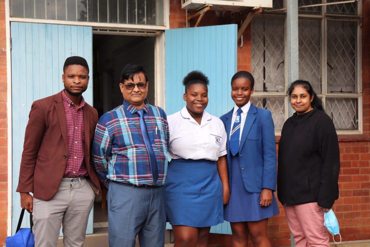 Pranesh Jugganath (second from left), deputy principal of Avoca Secondary School, stands with teachers and students at the school, where he hopes to introduce peace education into the curriculum. PHOTO: KATIE ROSTA '22/THE HAWK