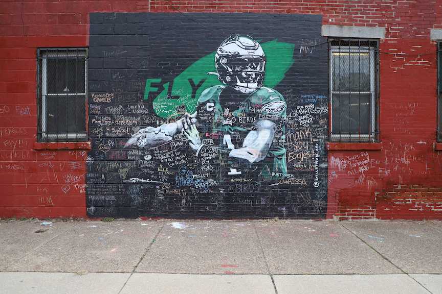 Eagles fans flocked to Fairmount to leave words of thanks and encouragement for quarterback Jalen Hurts. Artist Bill Strobel painted the mural and encouraged other fans to contribute to its message. PHOTO: KELLY SHANNON 24