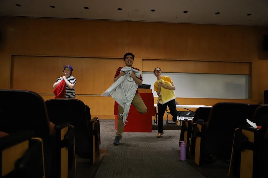 From left to right: Caroline Bouvier ’26, Liang Jun Ren ’25 and Sean Dyson ’23 during mid-rehearsal on April 16. PHOTO: KELLY SHANNON ’24/THE HAWK