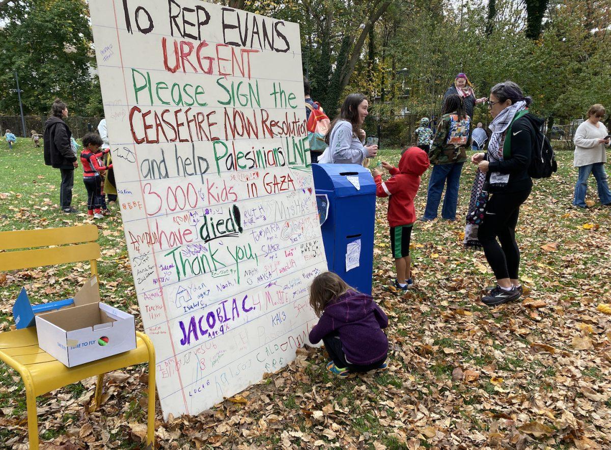 A child signs a large letter calling for Rep. Dwight Evans to support the Ceasefire NOW Resolution at the
Kids in Solidarity with Kids in Palestine event Oct. 29. PHOTO: ALLY ENGELBERT ’25/THE HAWK
