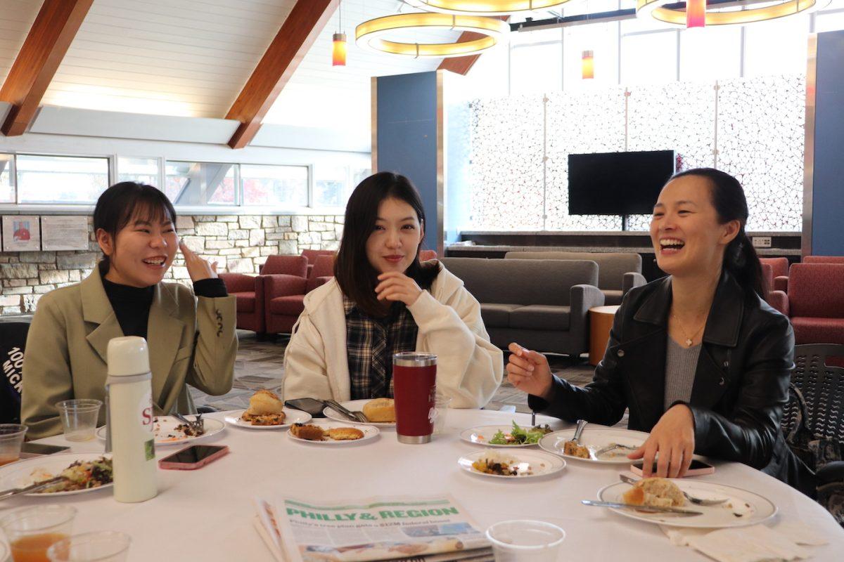 Two international students from Hunan Normal University sit with Julie Juan Yu (right), Ph.D., director
of China Program and Chinese Program, at a Nov. 17 Thanksgiving celebration for international
students in Cardinal Foley Campus Center. PHOTO: SAHR KARIMU ’26/THE HAWK