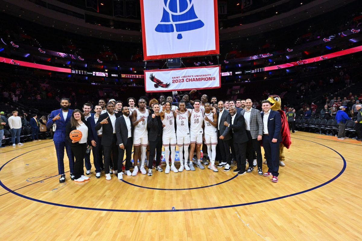 St. Joe’s men’s basketball team poses with the Big 5 Classic championship banner after defeating Temple University 74-65.
PHOTO COURTESY OF SIDELINE PHOTOS, LLC