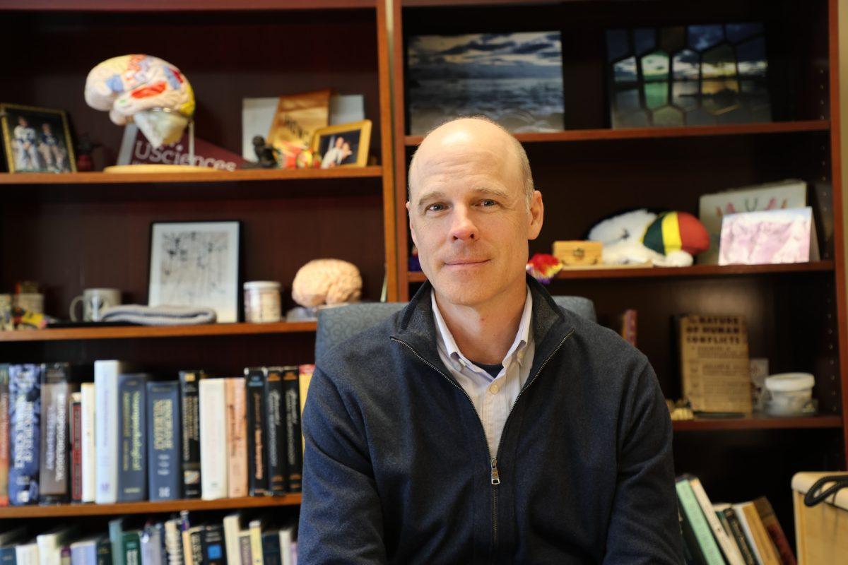 Steve Moelter, Ph.D., poses at his desk in his office located in Post Hall PHOTO: MAX KELLY ’24/THE HAWK