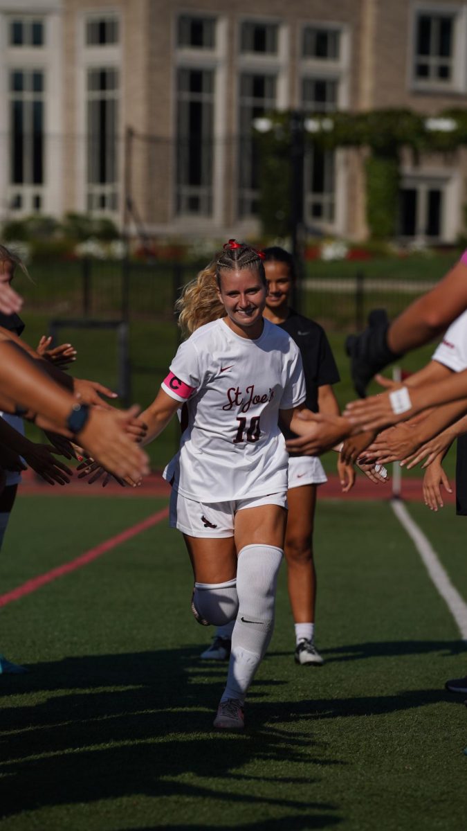 Natalie Nevins ’24, M.A. ’25 runs out after being announced for the starting lineup for St. Joe’s women’s soccer
game against Lafayette, Aug. 22. PHOTO COURTESY OF NATALIE NEVINS ’24, M.A. ’25/THE HAWK