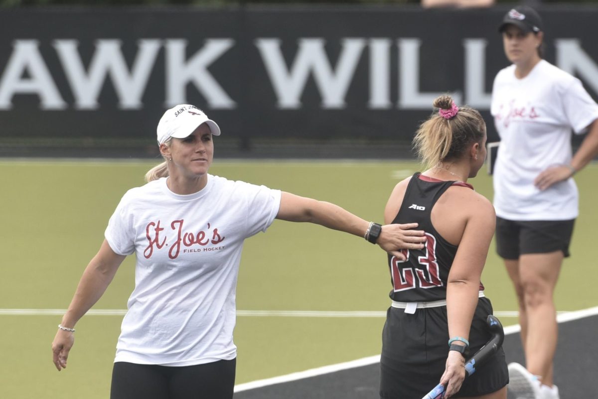 Field hockey head coach Hannah Prince offers encouragement to fifth-year Lily Santi during a game.
PHOTO: MIA MESSINA ’25/THE HAWK