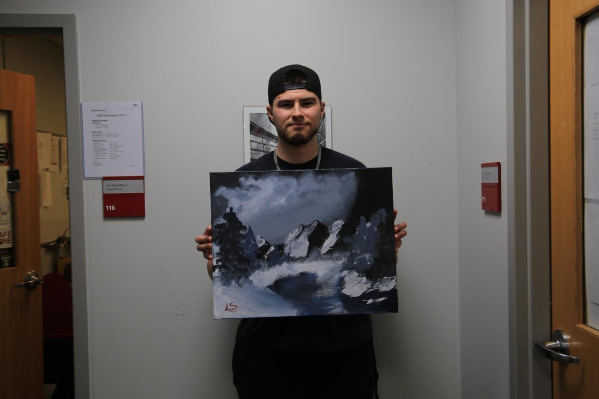 Luke Sanelli ’26 shows off his Bob Ross-instructed painting “Blue Winter” from an episode of “The Joys
of Painting.” PHOTO: ZACH PODOLNICK ’26/THE HAWK