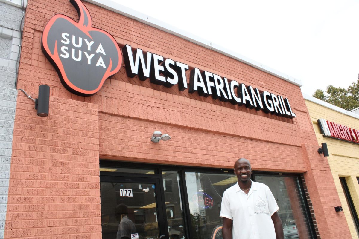 Dera Nd-Ezuma stands in front of Suya Suya West African Grill.