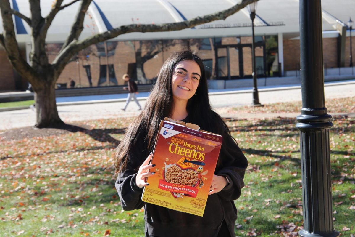 Alyssa Yannantuono ’26 holds a box of cereal pierced by a fork and wears dark clothes to embody her rendition of a “Cereal Killer.” PHOTOS: ZACH PODOLNICK ’26/THE HAWK