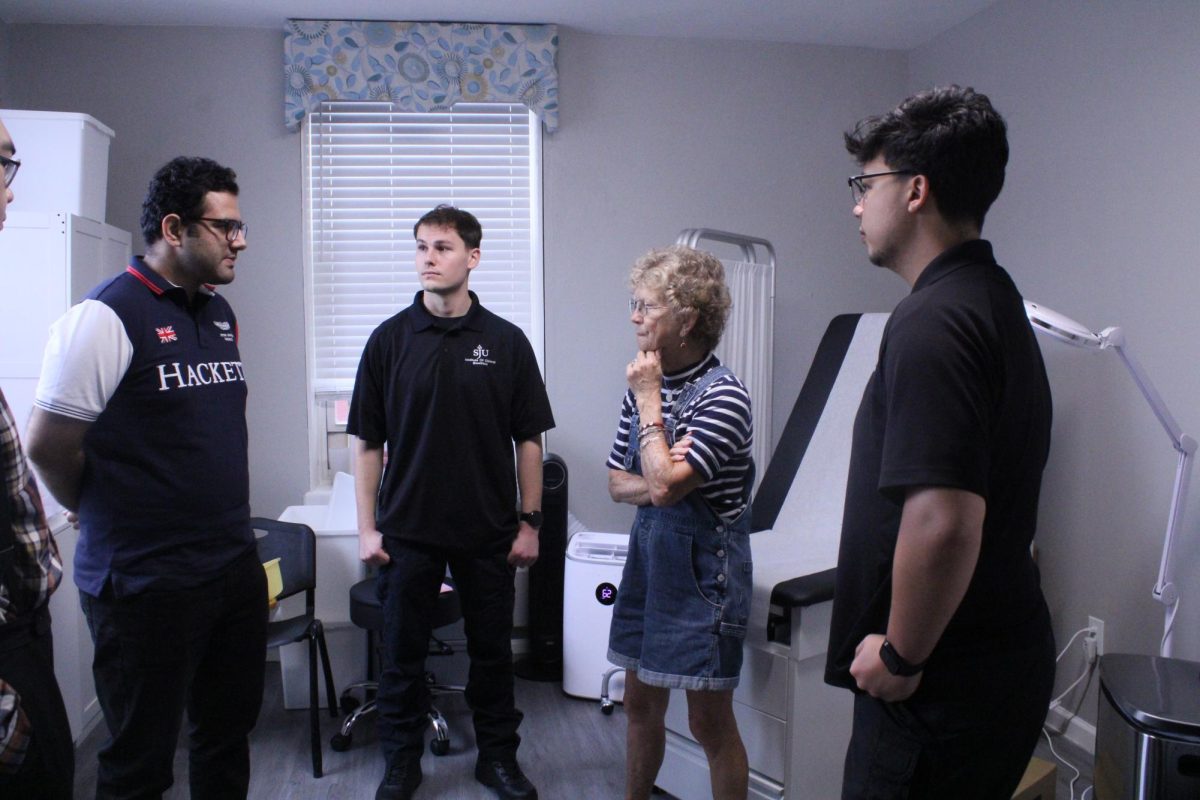 From left to right: Dr. Khizar Hayat, Josh Frantz ’26, retired nurse Mary Jo and Ean Hudak ’26 discuss the procedure for wound treatment in Mother of Mercy House. Formerly a spare room, the space was transformed into a medical office for the Institute of Clinical Bioethics at St. Joe’s.