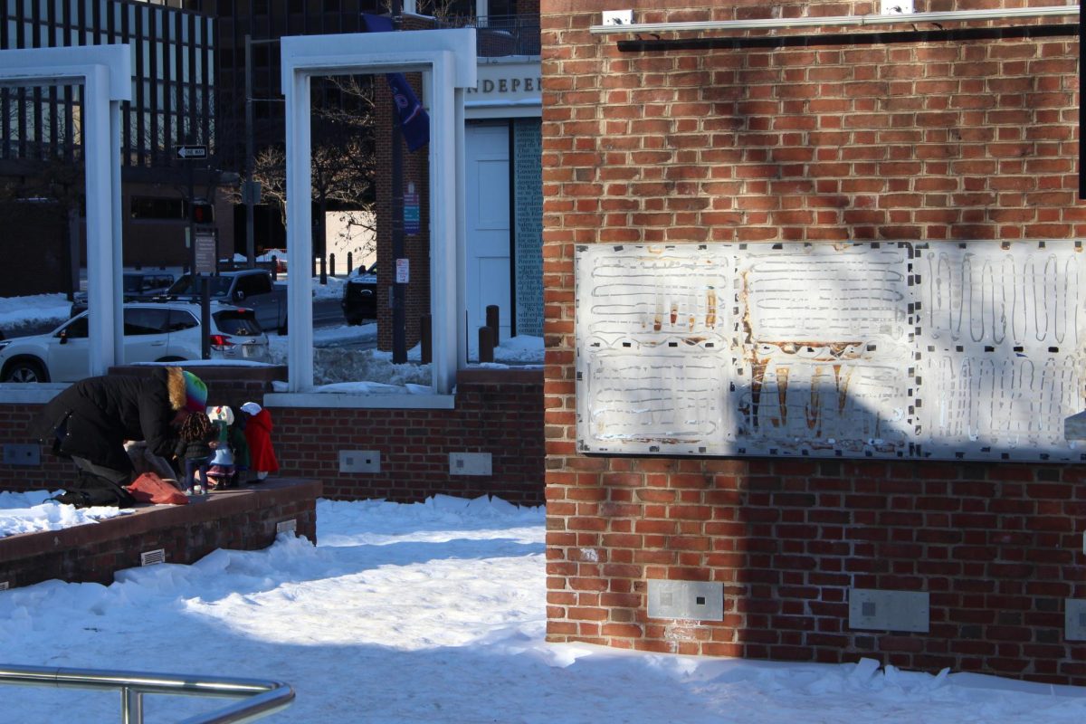 Community members pose American Girl Dolls holding protest signs at the President’s House after the plaques’ removals Jan. 31. PHOTOS: LUKE SANELLI ’26/THE HAWK