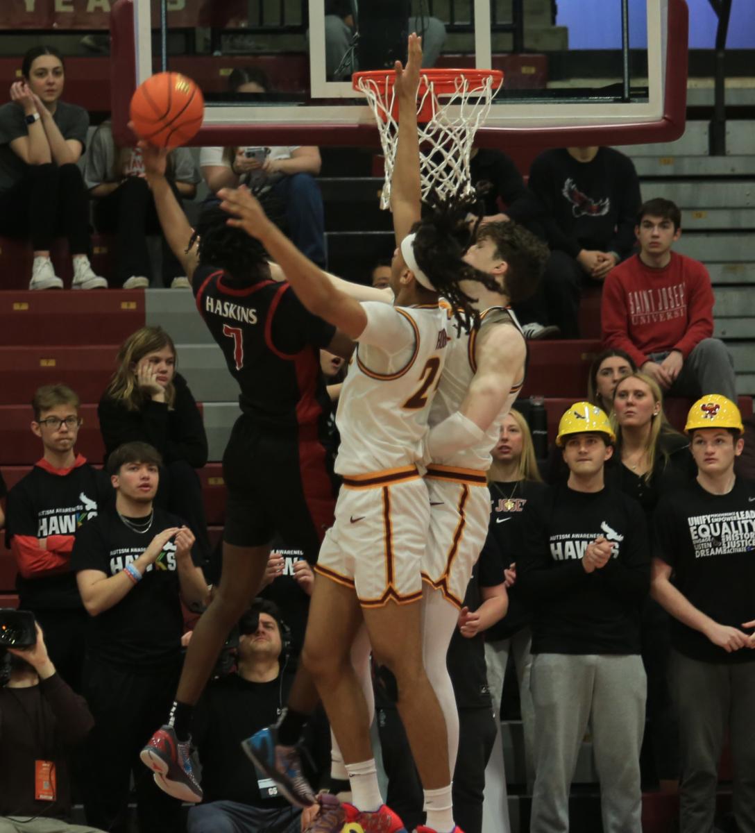 Sophomore guard Dasear Haskins attempts to dunk over two defenders during a game against Loyola Feb 21.
PHOTO: ZACH PODOLNICK ’26/THE HAWK